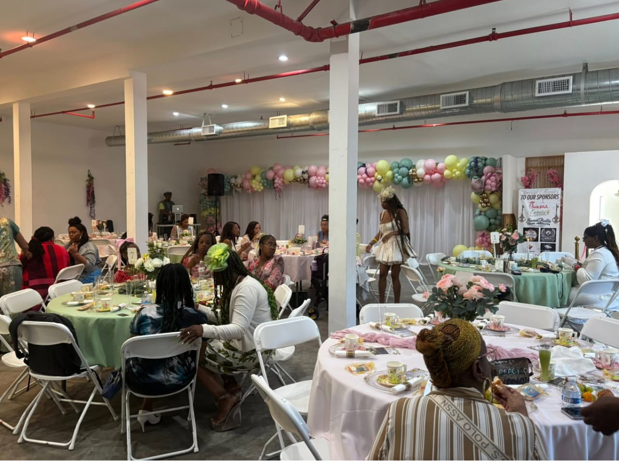 Seated tea party banquet with balloon garland and round tables