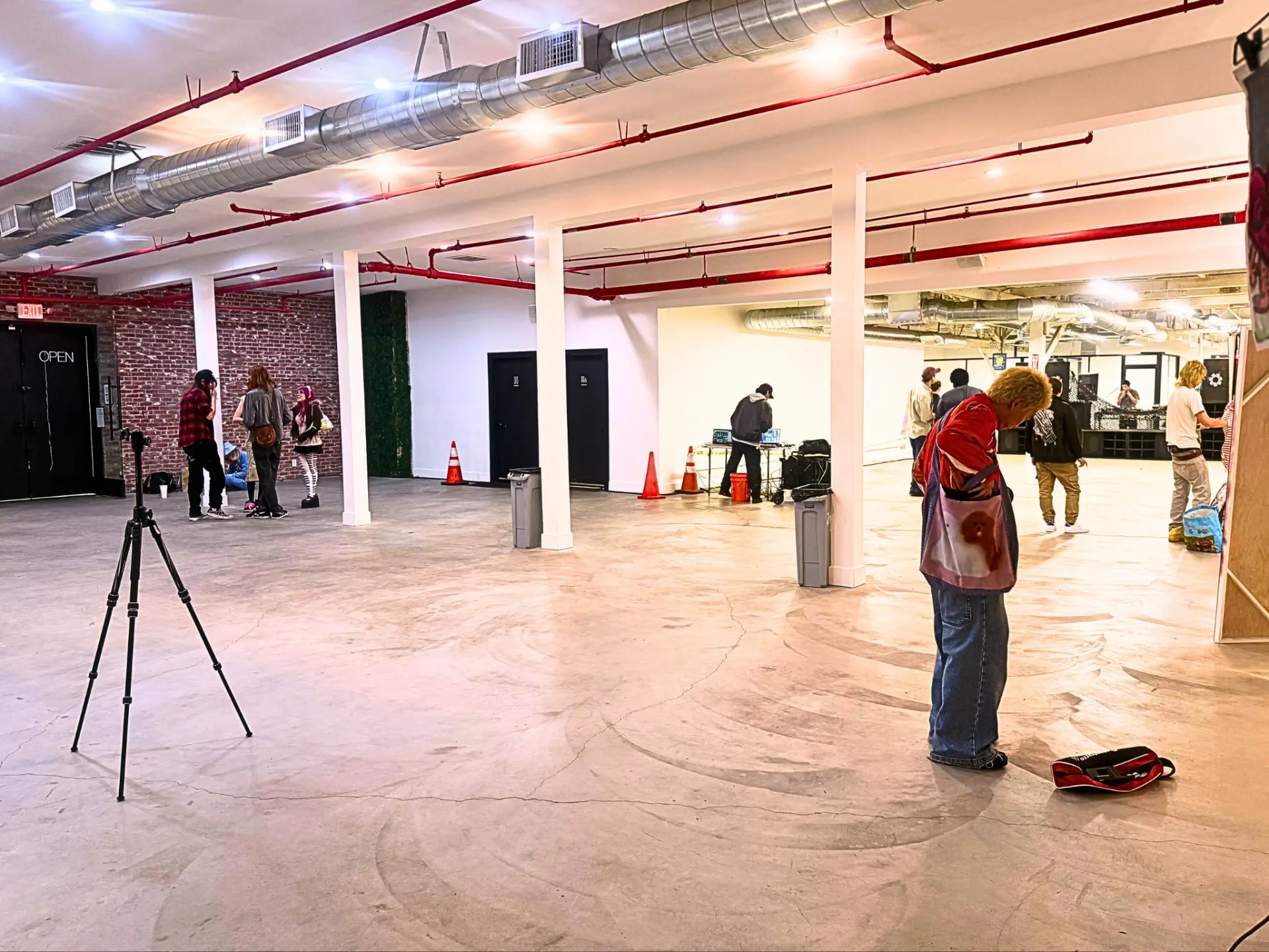 Creative event in progress with DJ setup and guests on the main floor